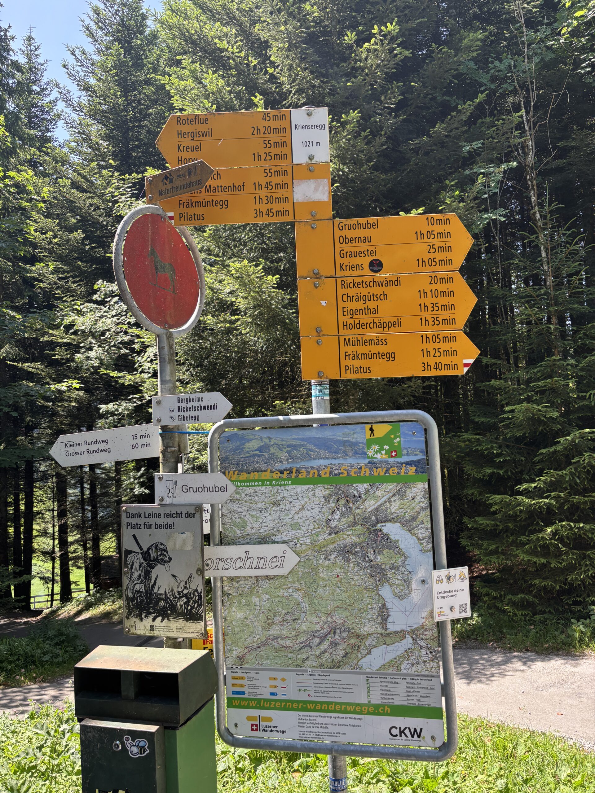 Gelbe Wanderwegweiser und Wanderkarte bei Krienseregg am Pilatus mit Richtungen nach Fräkmüntegg, Pilatus Kulm und Kriens.
